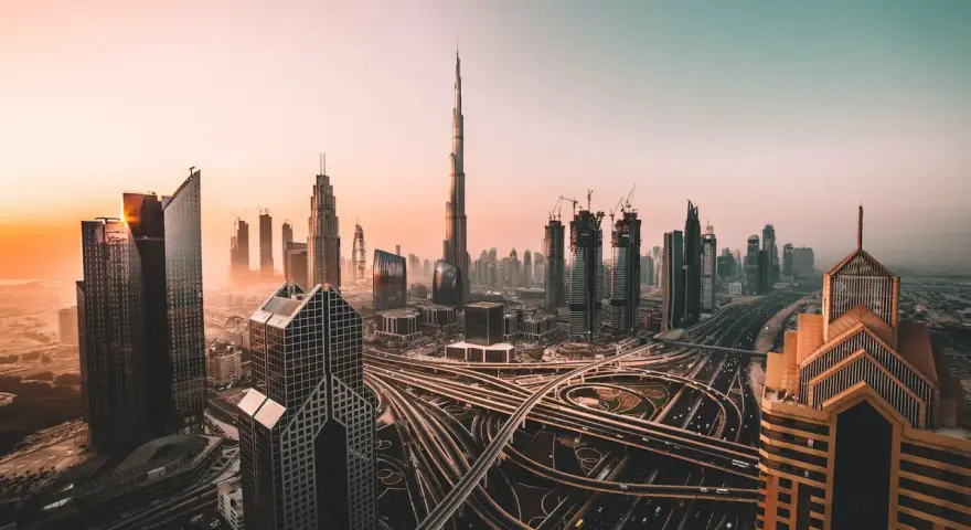 Zachód słońca nad Dubajem, z drapaczami chmur i skomplikowanymi węzłami drogowymi. Czy w Dubaju jest bezpiecznie? Tak, to nowoczesne miasto oferuje spokój.