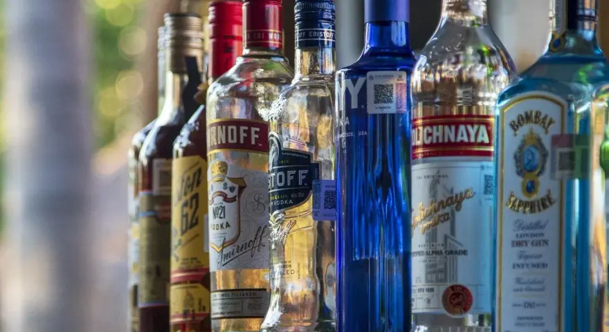 Rząd butelek alkoholu, w tym Smirnoff i Bombay Sapphire, sugeruje ceny alkoholu na Cyprze.