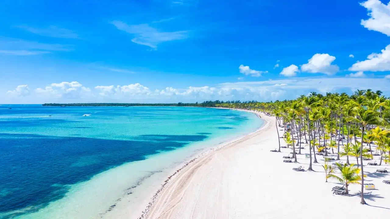Rajski widok na Bavaro Beach z turkusową wodą, białym piaskiem i palmami. Idealne miejsce na relaks.