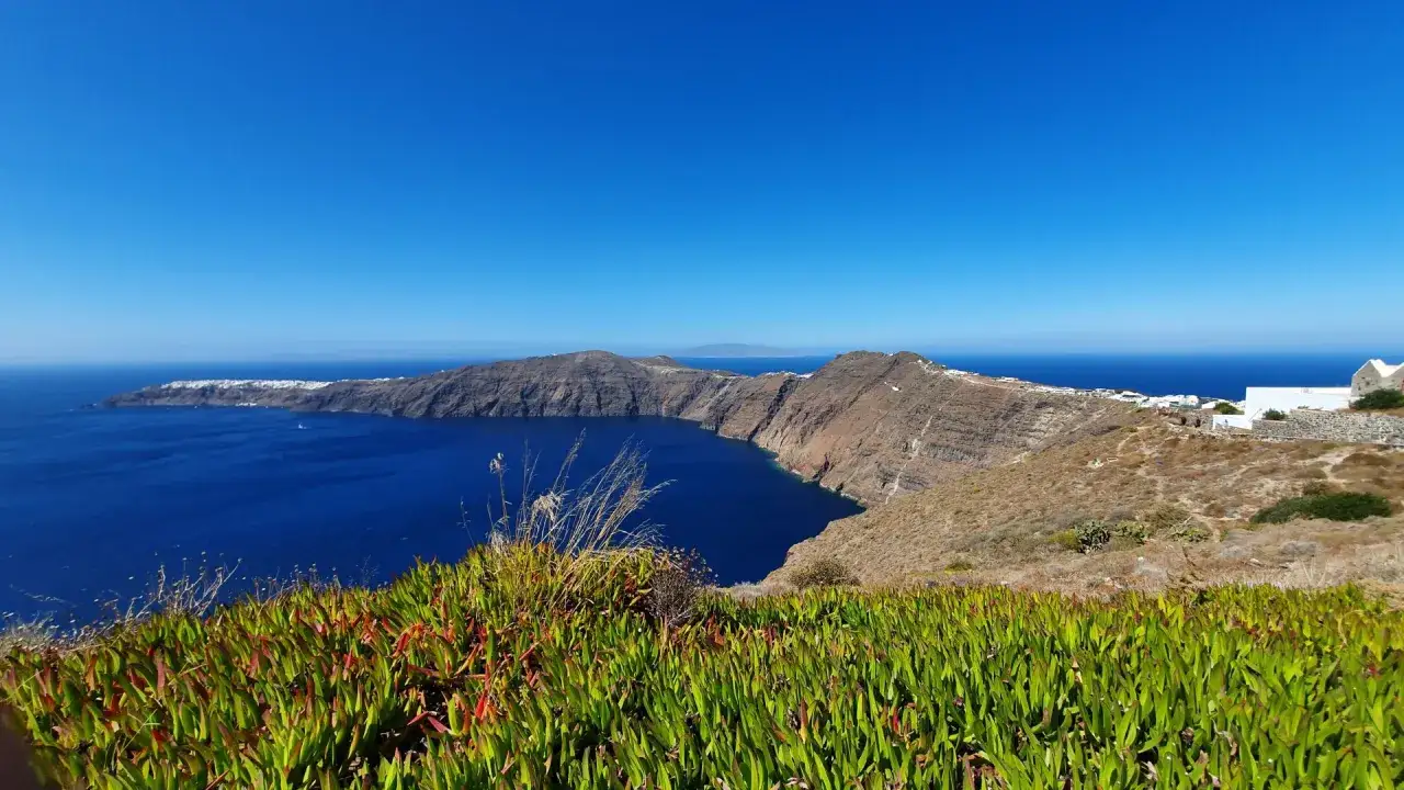 Widok na kalderę Santorini, białe domy na klifie i błękitne morze. Idealne miejsce na wakacje.