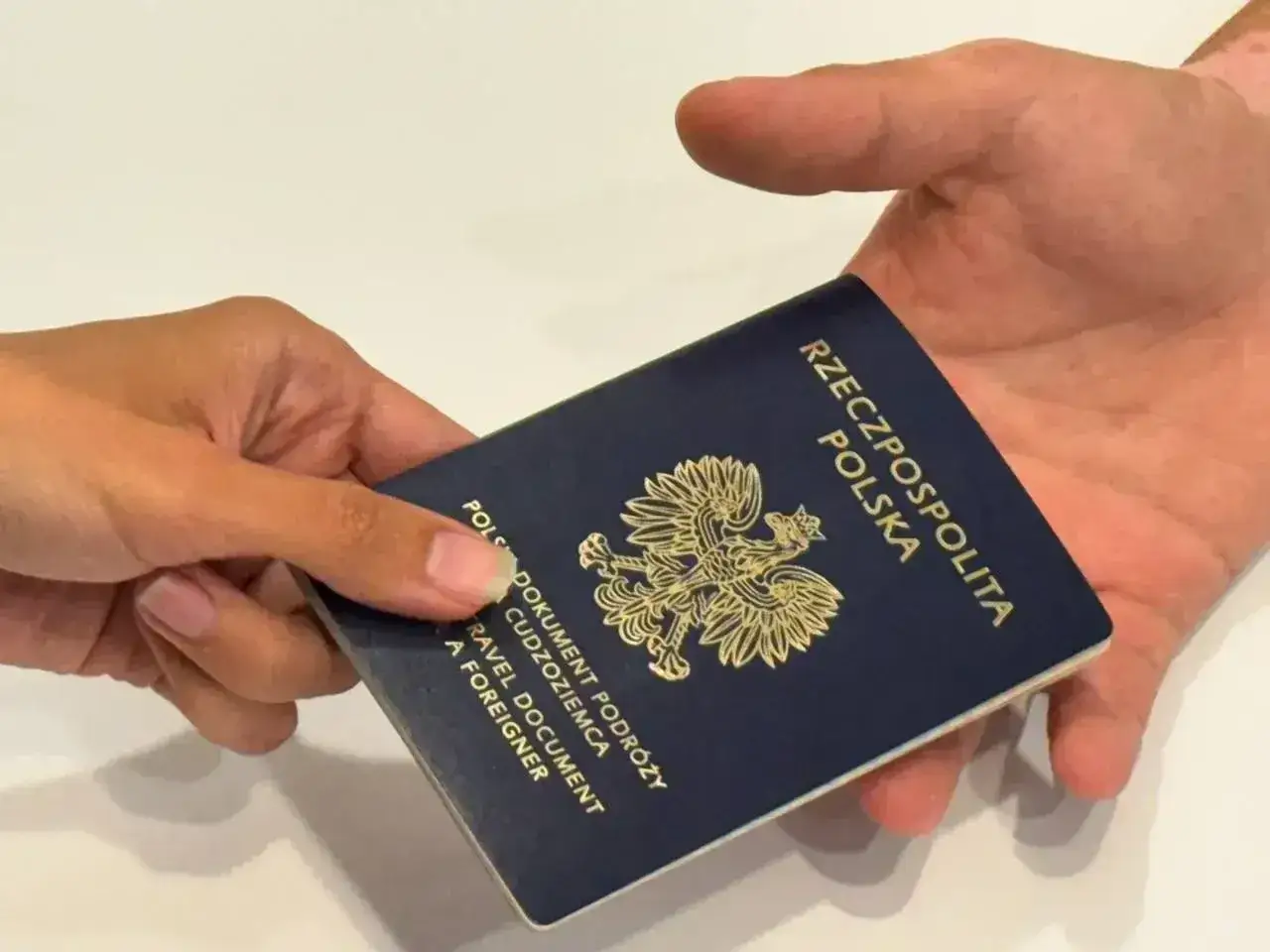 Paszport polski przekazywany z ręki do ręki. Czy do Bułgarii potrzebny jest paszport? Tak, do podróży do Bułgarii potrzebny jest paszport.