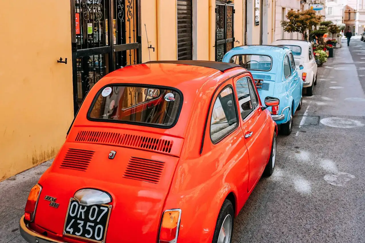 Pomarańczowy Fiat 500 i inne kolorowe klasyki czekają na Ciebie. Idealne do zwiedzania Sardynii! Wynajem auta Sardynia to świetny pomysł.