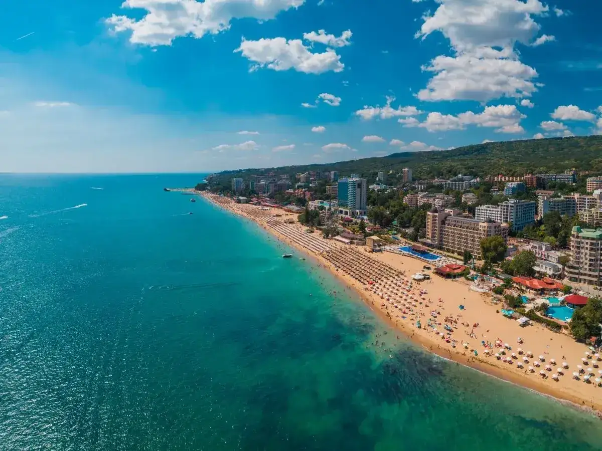 Słoneczne Złote Piaski zapraszają na wymarzone wakacje. Tłumy plażowiczów, turkusowe morze i hotele w tle tworzą idealny obraz letniego wypoczynku.