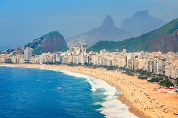 Copacabana w Rio de Janeiro, z tłumem na plaży i górami w tle. Czy do Brazylii potrzebna jest wiza? Sprawdź przed podróżą!