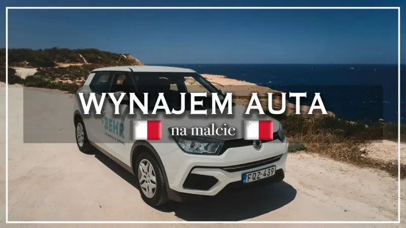 Biały samochód z napisem "Wynajem auta na Malcie" stoi na tle morza. Idealny do zwiedzania wyspy.