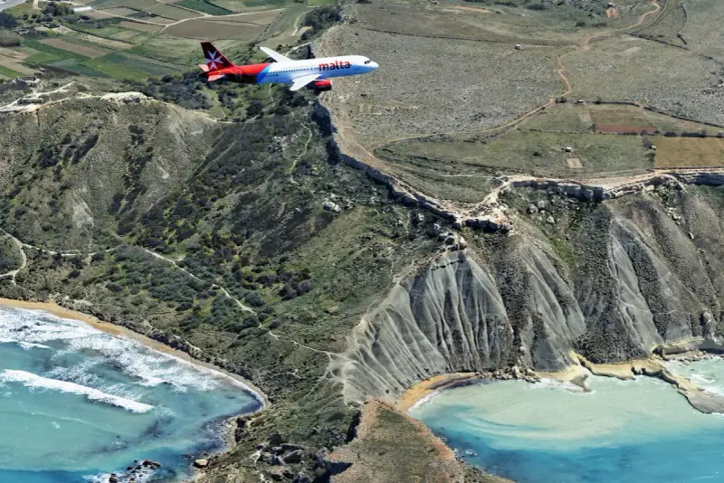 Samolot Malta Air przelatuje nisko nad klifami. Lotnisko Malta, niebezpieczne podejście do lądowania nad morzem.
